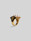 Three-quarter product shot of Noira natural pearl and gold sculptural ring on neutral background.