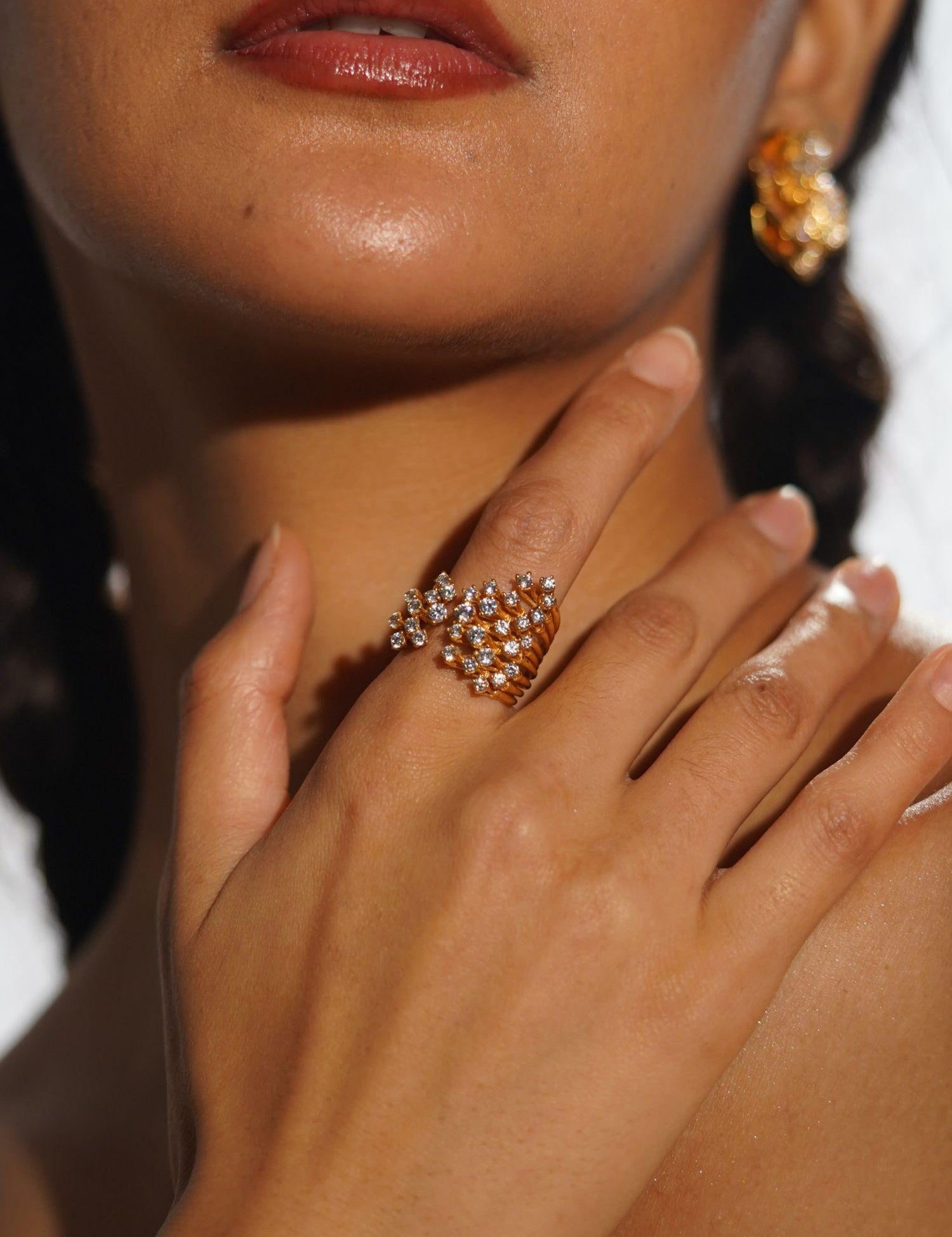 Nova star cocktail ring worn on hand in editorial portrait with matching statement earrings.