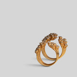 Nova sculptural star cocktail ring with zircons in 24k gold, front angle on neutral background.