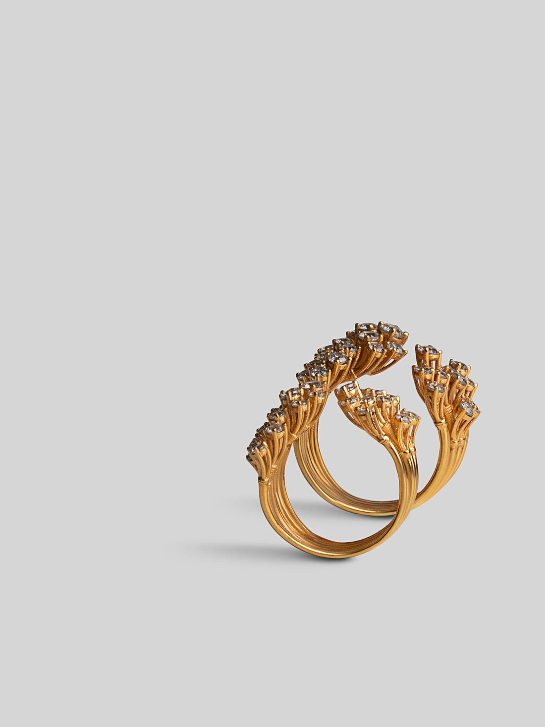 Nova sculptural star cocktail ring with zircons in 24k gold, front angle on neutral background.