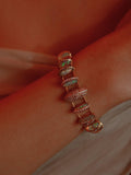 Opal crystal haze statement bracelet worn on wrist in a warm close editorial shot.