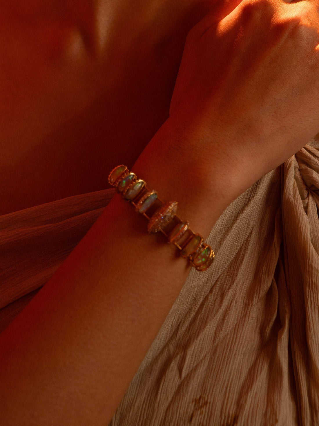 Opal Perspective designer bracelet with opal and zircon stones worn on wrist in warm light.