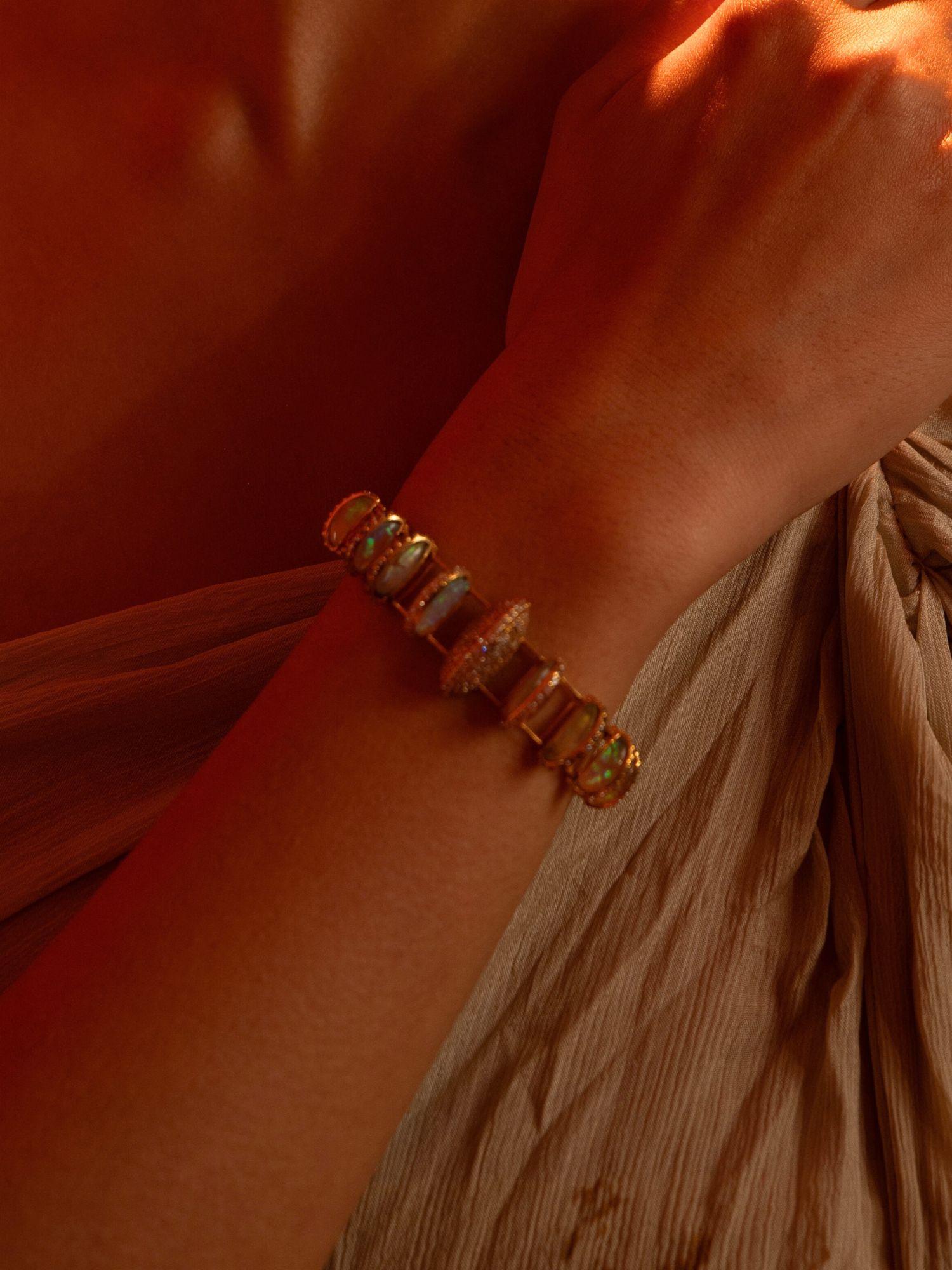 Opal Perspective designer bracelet with opal and zircon stones worn on wrist in warm light.