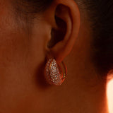 Opal Perspective reversible earrings worn front-facing in dramatic warm editorial lighting.