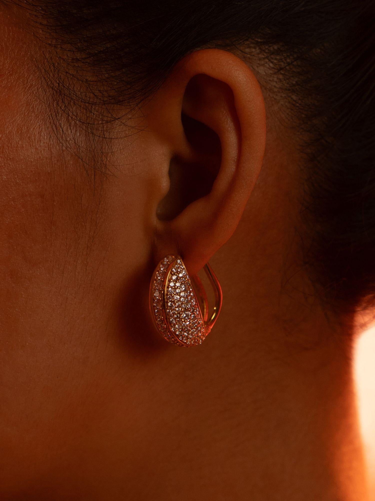 Opal Perspective reversible earrings worn front-facing in dramatic warm editorial lighting.