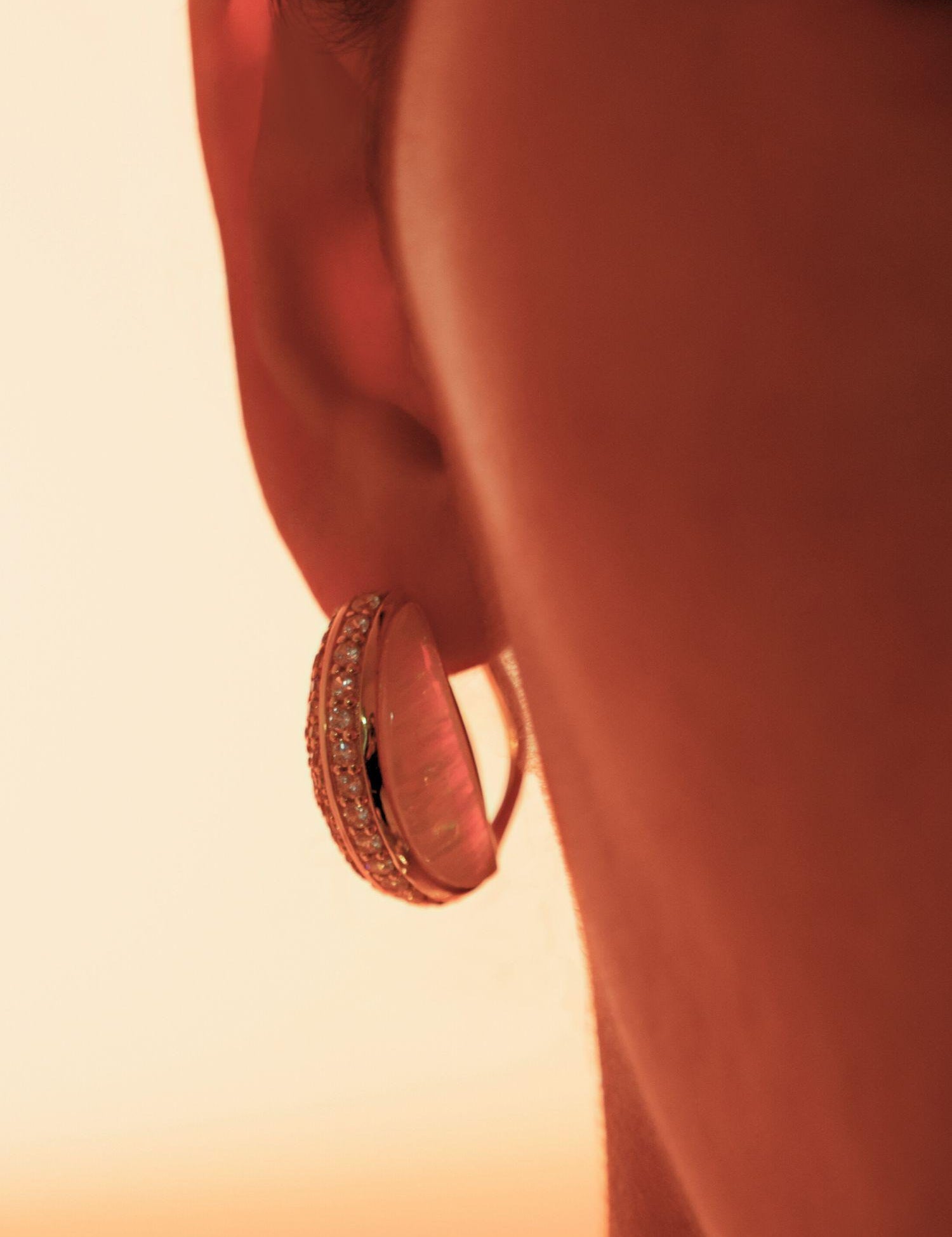Close profile of Opal Perspective reversible statement earrings in 24k gold against warm skin.
