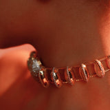 Opal crystal haze necklace worn close to the décolletage in a warm editorial close-up.
