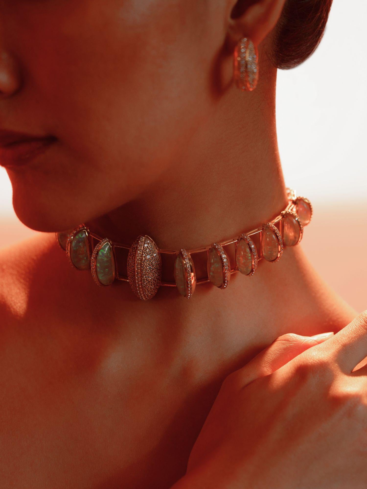 Opal Perspective statement necklace worn in a soft portrait, model's hand resting at collarbone.