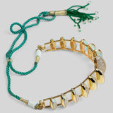 Full flat lay of Opal Perspective opal necklace with green tassel cord and gold stone settings.
