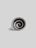 Orbis cocktail ring with spiral black enamel and zircon detail in white rhodium, front angle on neutral background.