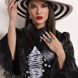 Model wearing gold Orbis cocktail ring with zircon and enamel spiral optical illusion detail