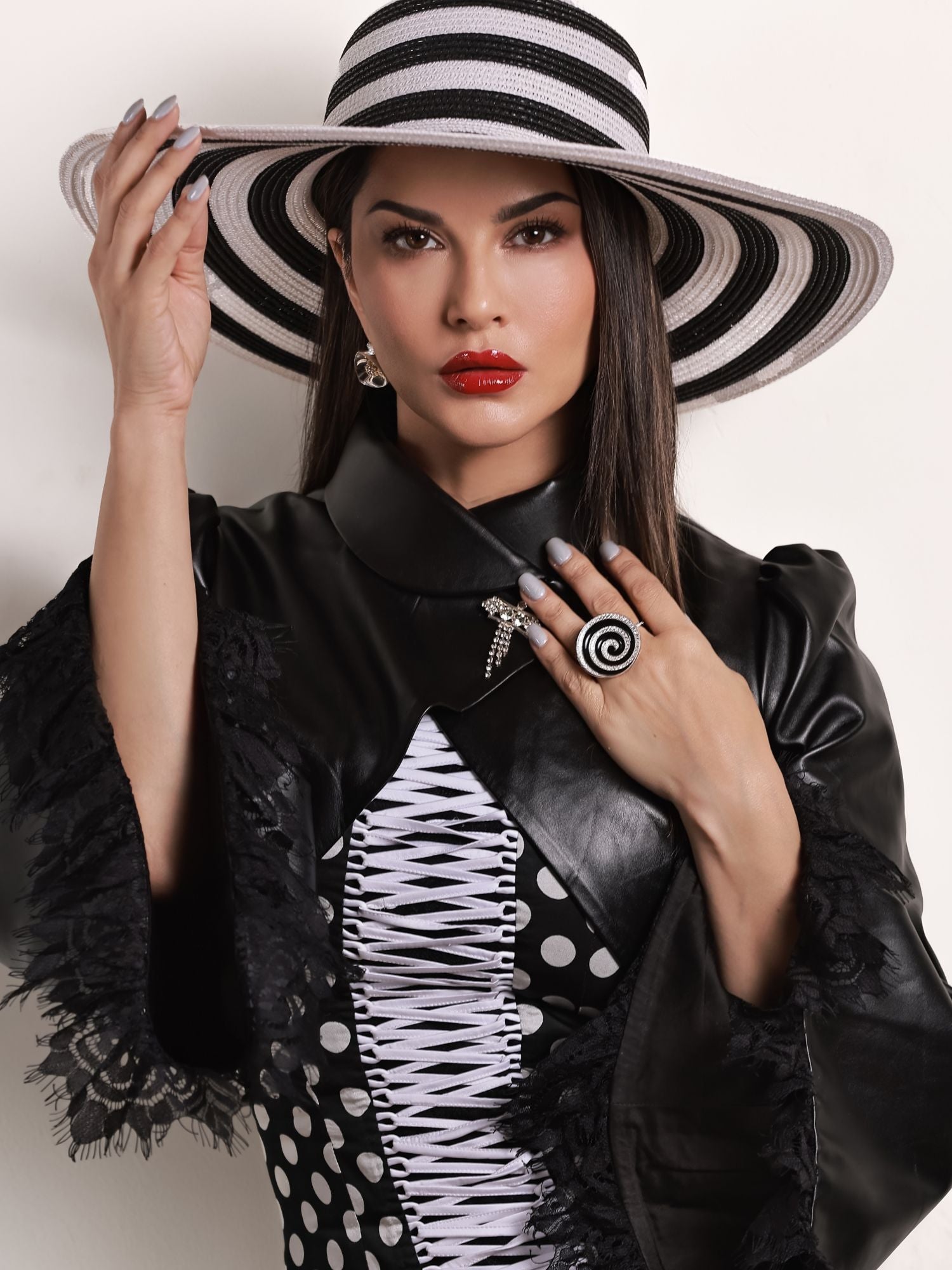 Model wearing gold Orbis cocktail ring with zircon and enamel spiral optical illusion detail