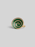 Three-quarter product shot of Orbis green enamel spiral ring in 24k gold on neutral background.