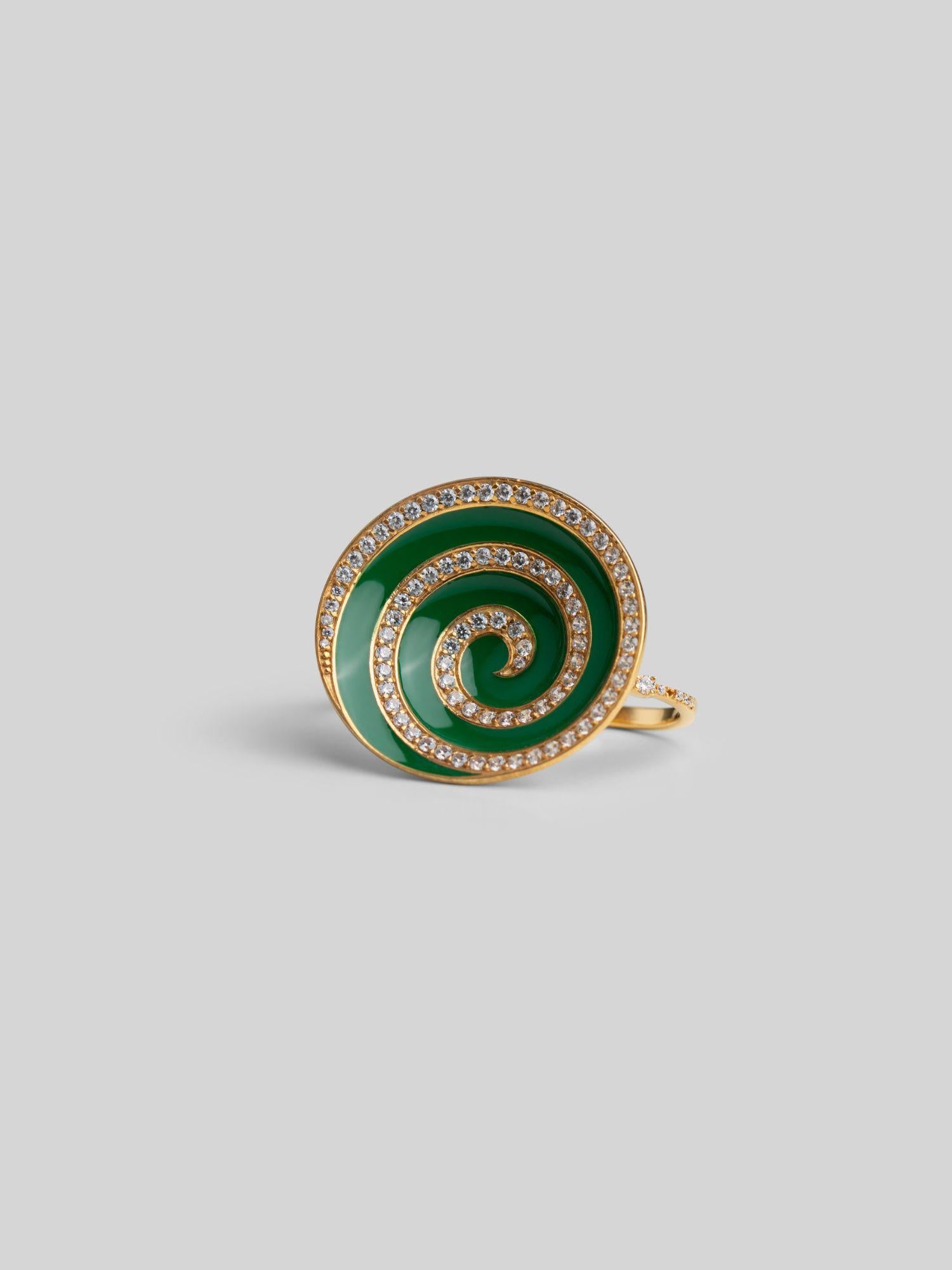 Three-quarter product shot of Orbis green enamel spiral ring in 24k gold on neutral background.
