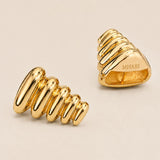 Pebble Triangle earrings in 24k gold showing 3D geometric form and MHARI engraving, magnetic closure visible.