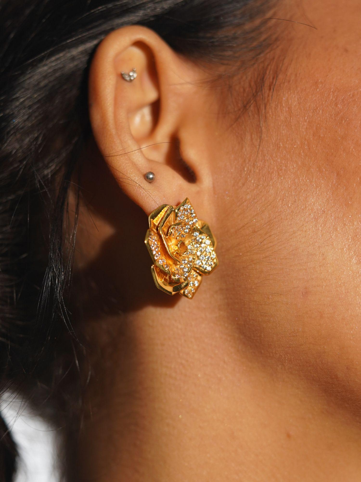 Rosara rose-form statement stud earring in white CZ and gold worn on model in profile close-up.
