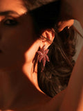 Model wearing sculptural CZ starfish earrings in warm dramatic lighting