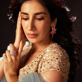 Model in ethnic wear wearing CZ ombre starfish earrings looking downward, warm light