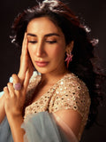 Model in ethnic wear wearing CZ ombre starfish earrings looking downward, warm light
