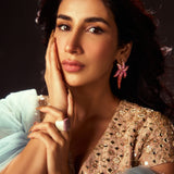 Model in ethnic wear wearing CZ ombre starfish earrings looking into camera