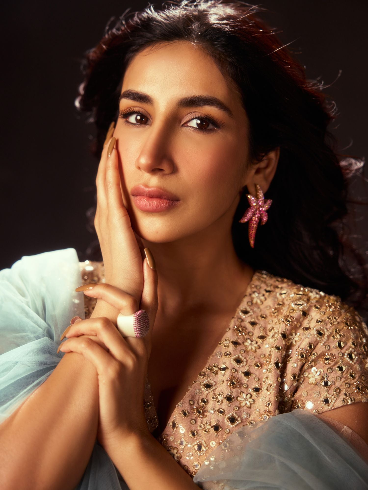 Model in ethnic wear wearing CZ ombre starfish earrings looking into camera