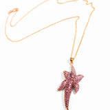 Minimalist product shot of gold starfish pendant necklace on white background