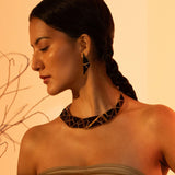 Tsugumi kintsugi statement earrings worn in profile showing full triangular drop length on model.