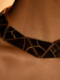 Tsugumi kintsugi statement necklace worn close to décolletage showing gold crack detail on black panels.