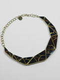 Tsugumi kintsugi necklace with black enamel panels and gold crack detail, full length with chain on neutral background.