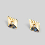 Vélora layered diamond stud earrings with blue cubic zirconia in 24k gold on neutral background.