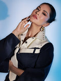 Model wearing gold Velora layered zircon earrings, hand near chin in blue-toned portrait