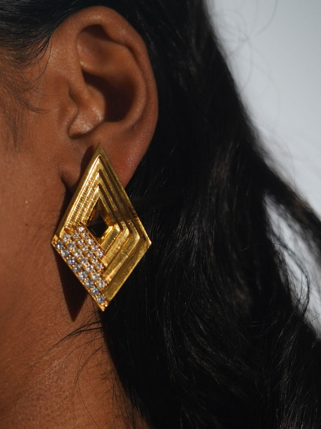 Vélora layered diamond stud earrings with white cubic zirconia in 24k gold on neutral background.