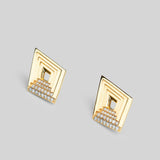 Vélora layered diamond stud earrings with white cubic zirconia in 24k gold on neutral background.