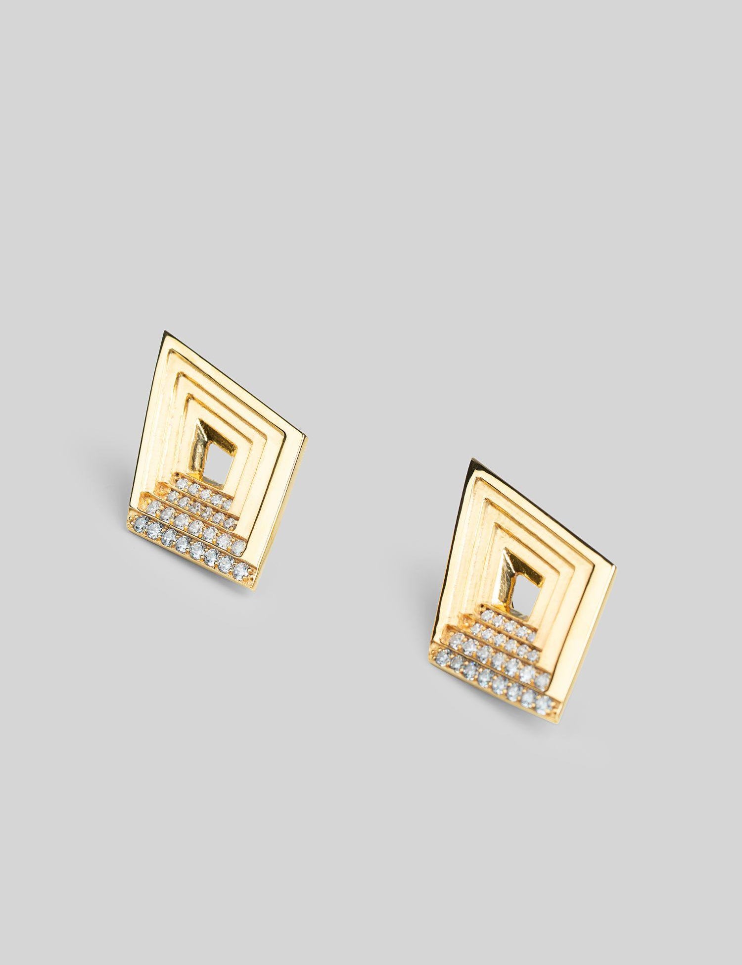 Vélora layered diamond stud earrings with white cubic zirconia in 24k gold on neutral background.