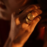 Model wearing bold gold dome curve ring, warm close-up on hand