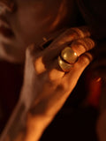 Model wearing bold gold dome curve ring, warm close-up on hand