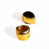 Angled shot of gold and black rhodium dual rings showing curved form