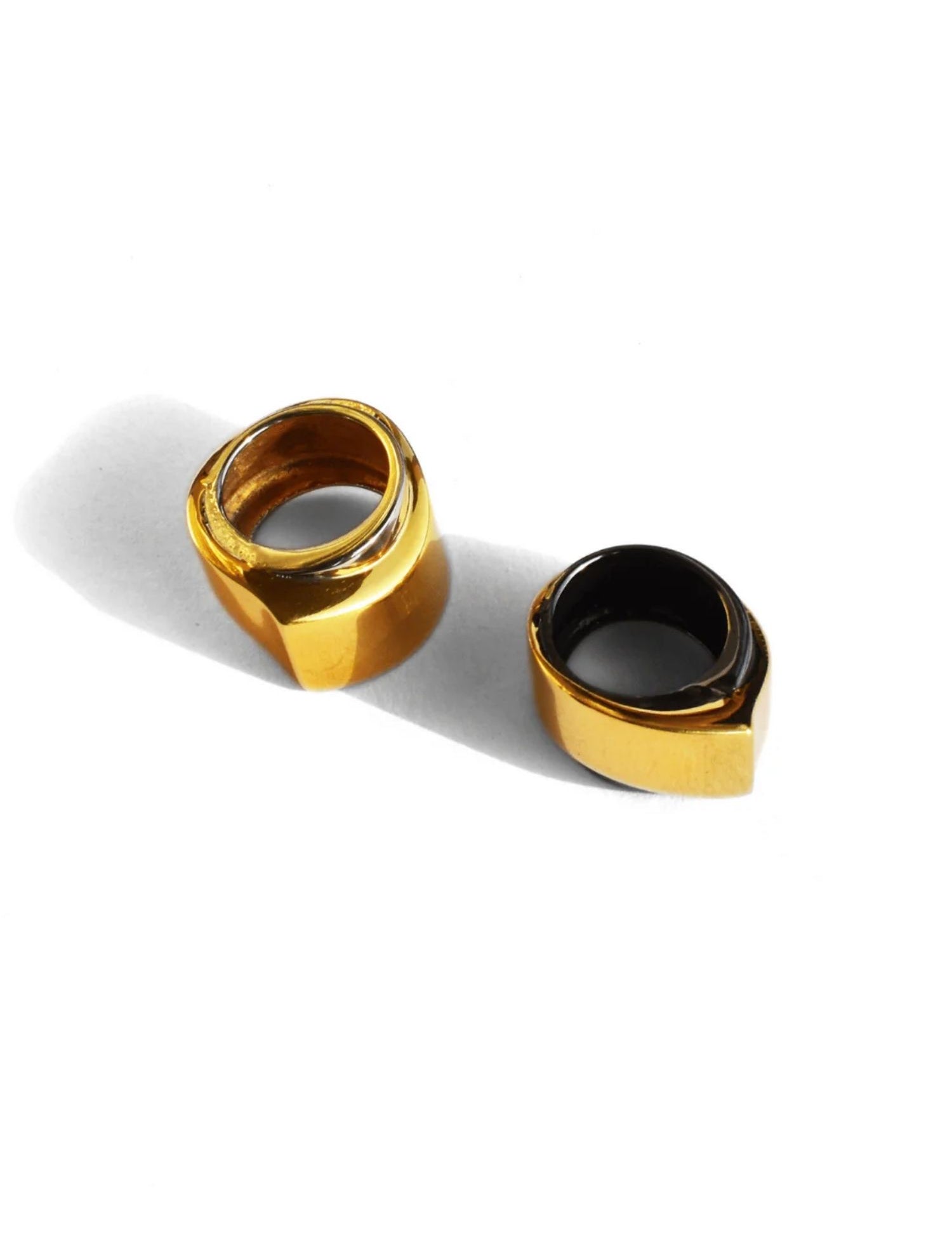Two-tone gold and black rhodium dual cocktail rings on white background