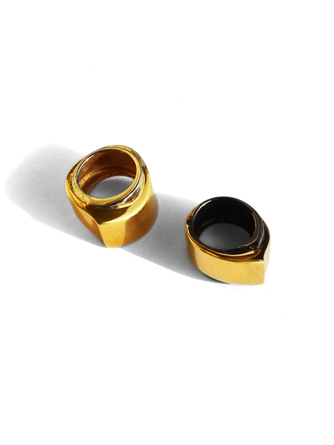 Two-tone gold and black rhodium dual cocktail rings on white background