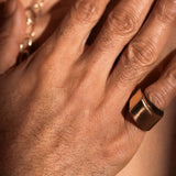 Close-up of gold dual ring on model's hand showing sculptural band width