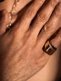 Close-up of gold dual ring on model's hand showing sculptural band width
