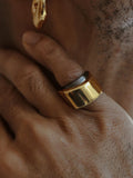 Model wearing dark grey and gold two-tone dual ring on hand in low light