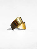 Angled product shot of gold ribbon ring showing twisted form and mixed finish