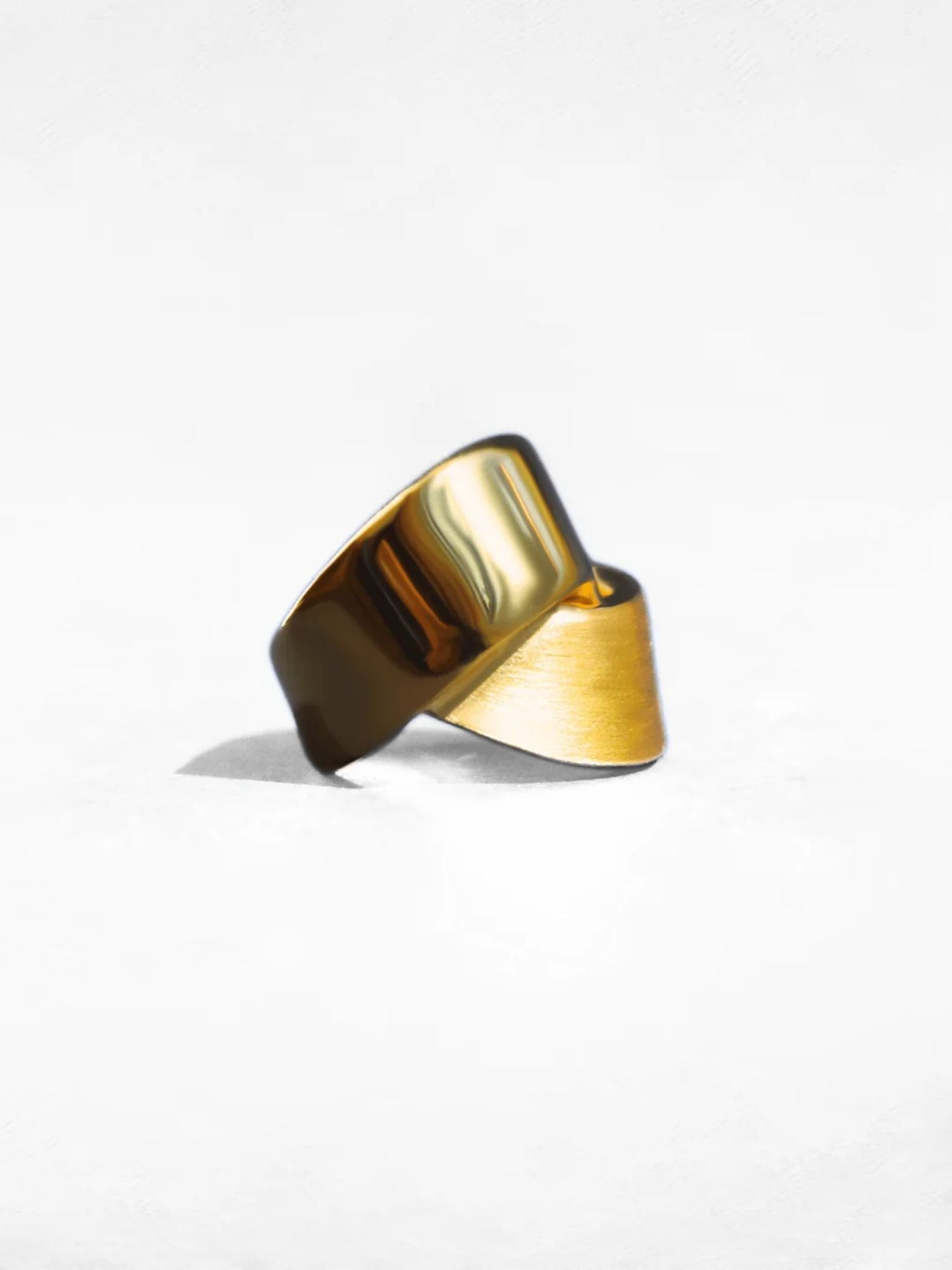 Angled product shot of gold ribbon ring showing twisted form and mixed finish